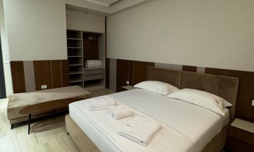 a bedroom with a large bed with two towels on it at Anchor Luxury Rooms in Vlorë