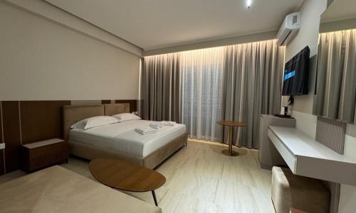 a hotel room with a bed and a television at Anchor Luxury Rooms in Vlorë