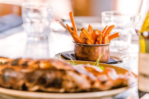 a table with a plate of fries and a plate of food at Holiday Inn Brentwood by IHG in Brentwood
