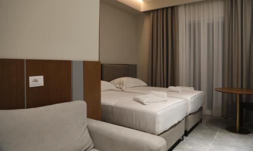 a hotel room with two beds and a couch at Anchor Luxury Rooms in Vlorë