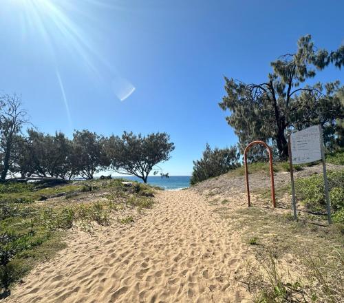 a beach with a sign next to the water at 1770 Holiday Village in Seventeen Seventy