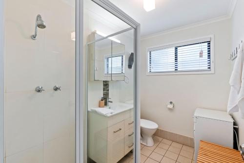 ein Badezimmer mit Dusche, Waschbecken und Toilette in der Unterkunft Manyana Beach Break in Manyana