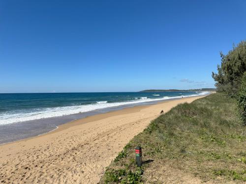 a sandy beach with people walking on it next to the ocean at 1770 Holiday Village in Seventeen Seventy
