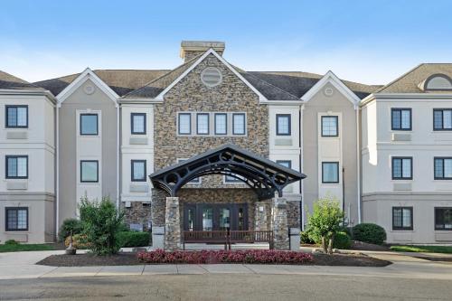 a large apartment building with an arch in front of it at Staybridge Suites Columbia - Baltimore by IHG in Columbia