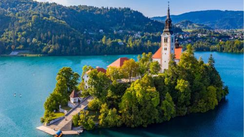 an island in the middle of a lake with a church at InterContinental - Ljubljana by IHG in Ljubljana