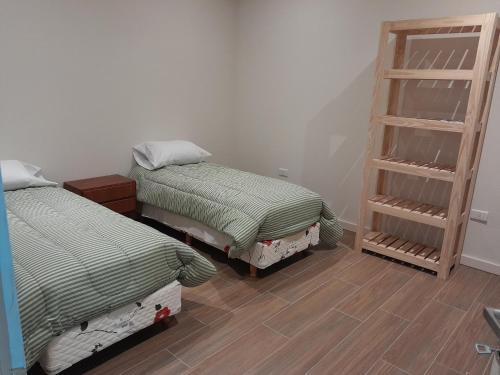 a room with two beds and a book shelf at La tranquera in La Paz