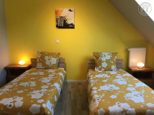 two beds in a room with yellow walls at Maison spacieuse pour 8 pers avec jardin, terrasse, WIFI, proche commerces et attractions culturelles - FR-1-510-156 in Aniche
