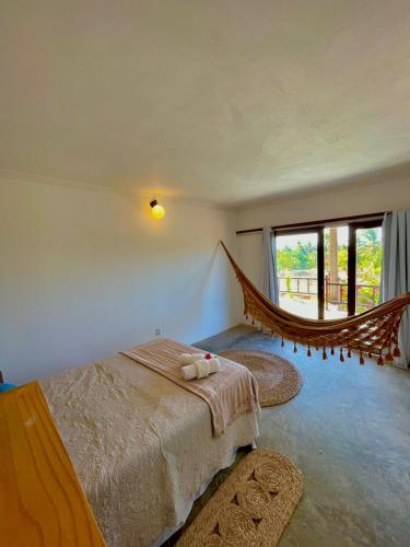a bedroom with a bed and a large window at Morada do Vento in Guriú