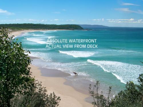 a beach with the words absolute waterfront actual view from deck at Manyana Beach Break in Manyana