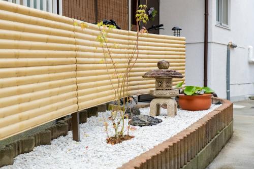 a japanese garden with a bamboo fence at KOISI Renovated traditional Japanese house 12min walk fm広島駅 Max5ppl 3LDK in Hiroshima