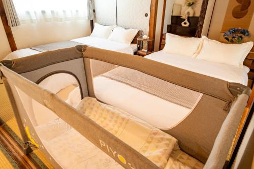 two twin beds in a room with at KOISI Renovated traditional Japanese house 12min walk fm広島駅 Max5ppl 3LDK in Hiroshima
