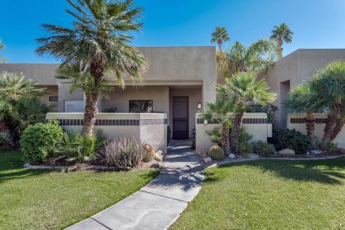 a house with palm trees in front of it at Desert Country Club Paradise! in Cathedral City