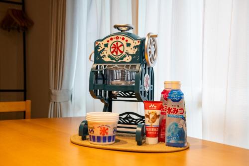 a robot sitting on a table with cups of coffee at KOISI Renovated traditional Japanese house 12min walk fm広島駅 Max5ppl 3LDK in Hiroshima