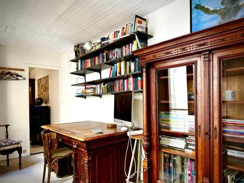 Cette chambre comprend un bureau avec un ordinateur et une étagère à livres. dans l'établissement DELUX2 Rooms Large Studio Marais, à Paris