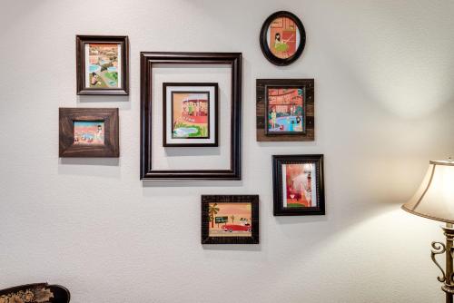 a group of framed pictures on a wall with a clock at Desert Country Club Paradise! in Cathedral City