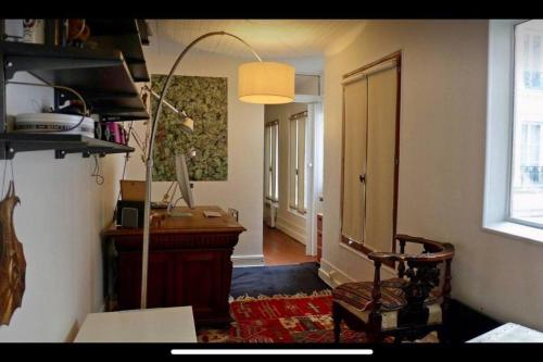 Cette chambre dispose d'un bureau, d'une chaise et d'une fenêtre. dans l'établissement DELUX2 Rooms Large Studio Marais, à Paris