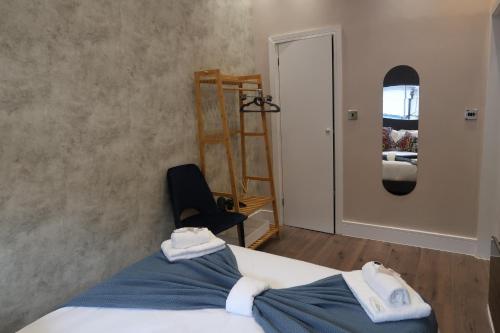 a bedroom with a bed and a chair and a mirror at Quaint Retreat In The Historic District Local in Sherborne