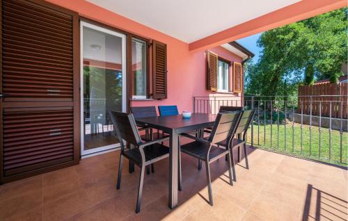 een eettafel en stoelen op een balkon bij Awesome Home In Sveti Lovrec Labinski in Diminići