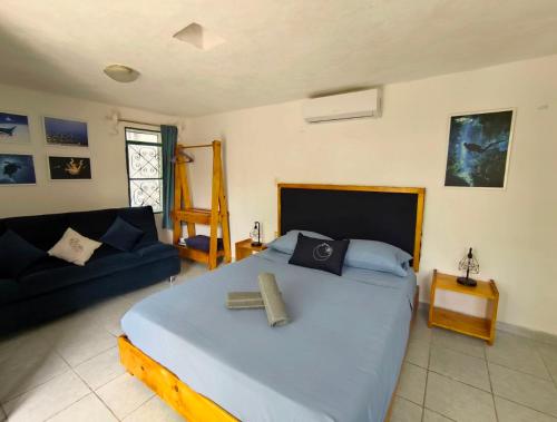 a bedroom with a large bed and a couch at Studios Yaxkin, located in downtown in Cozumel