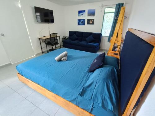 a bedroom with a blue bed and a couch at Studios Yaxkin, located in downtown in Cozumel