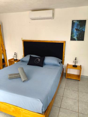 a bedroom with a bed with a blue comforter at Studios Yaxkin, located in downtown in Cozumel