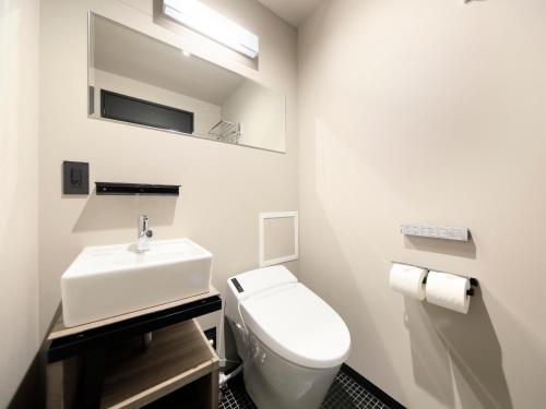 a bathroom with a white toilet and a sink at QuintessaHotel FukuokaHakata Relax&Sleep in Fukuoka