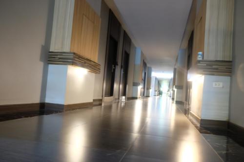 an empty hallway of a building with a long floor at Eastpana Executive Residence 304 Prachinburi in Si Maha Phot