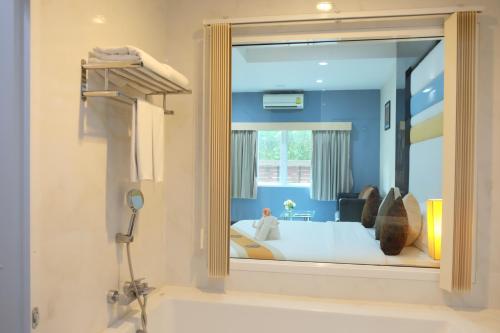a bathroom with a large mirror over a bath tub at Eastpana Executive Residence 304 Prachinburi in Si Maha Phot