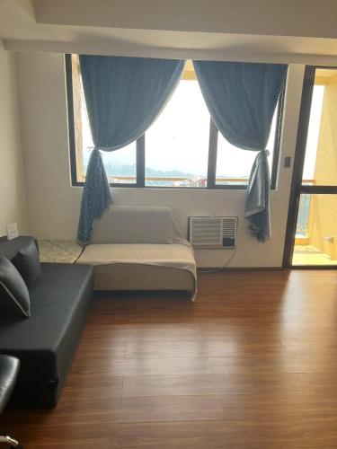 a living room with a bed and a large window at Splendido Tagaytay Taal Lake Staycation Free Parking Netflix No Free Pool in Tagaytay