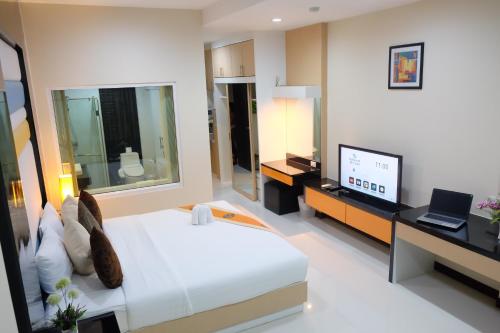 a hotel room with a bed and a television at Eastpana Executive Residence 304 Prachinburi in Si Maha Phot
