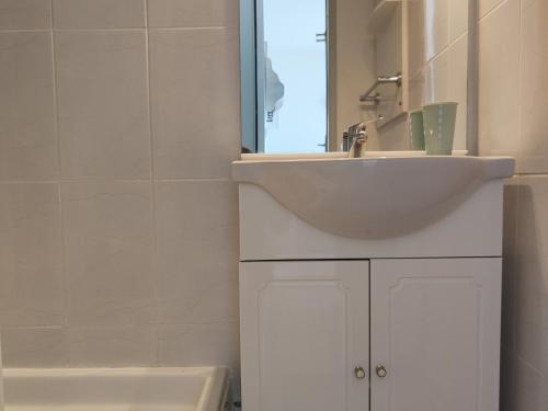 une salle de bain avec un lavabo, un miroir et une baignoire dans l'établissement Appartement Bord de Mer - Climatisation, Balcon, Parking et Piscine - FR-1-801-3, au Cap d'Agde