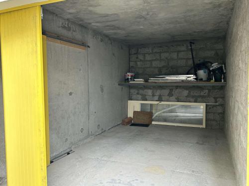 une pièce inachevée avec une cheminée et une porte jaune dans l'établissement Appartement rénové 2 pièces avec balcon, à 200m de la plage, St Hilaire de Riez - FR-1-224C-318, à Saint-Hilaire-de-Riez