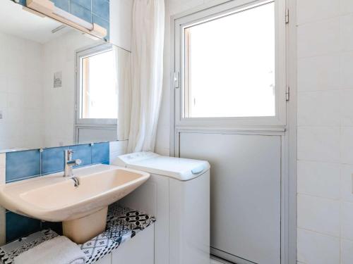 une salle de bain blanche avec un lavabo et une fenêtre dans l'établissement Studio cabine climatisé près de la plage avec parking à Narbonne - FR-1-409-274, à Narbonne