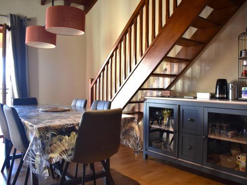 une salle à manger avec une table et un escalier dans l'établissement Charmant Duplex Mezzanine avec Parc, Aire de Jeux et Parking - Centre Font-Romeu - FR-1-580-115, à Font-Romeu-Odeillo-Via