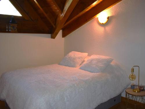 une chambre avec un lit blanc avec deux oreillers dans l'établissement Charmant Duplex Mezzanine avec Parc, Aire de Jeux et Parking - Centre Font-Romeu - FR-1-580-115, à Font-Romeu-Odeillo-Via