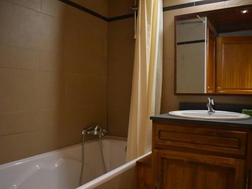 une salle de bain avec un lavabo, une baignoire et un miroir dans l'établissement Charmant Duplex Mezzanine avec Parc, Aire de Jeux et Parking - Centre Font-Romeu - FR-1-580-115, à Font-Romeu-Odeillo-Via