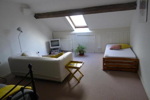 um quarto com um sofá, uma cama e uma janela em Totters Hostel em Caernarfon