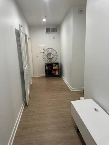 a hallway with white walls and a wooden floor at The Carlton - Modern-Lux 2 Master Suites-Secure Bldg & Parking- 5 BLKS to Ocean Ave in Los Angeles