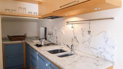 a kitchen with a sink and a marble counter top at Attico Novecento in Porto San Giorgio