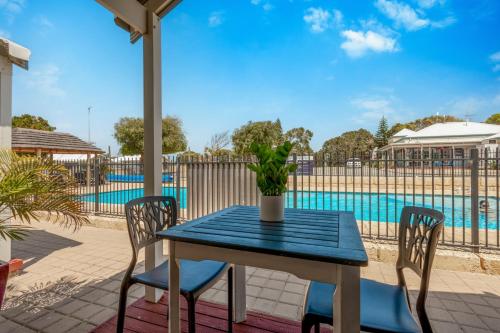 a blue table and chairs on a patio with a pool at BIG 4 Tasman Holiday Parks - Ledge Point in Ledge Point