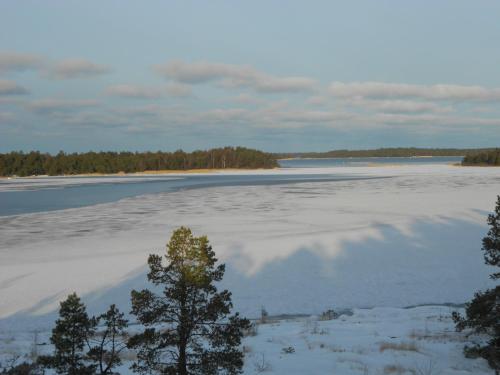 a large body of water with trees and snow at Tornvillan in Hammarland