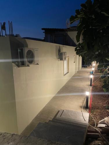 a white building with lights on the side of it at Joal Rooms in Sarandë