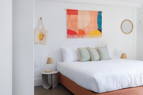 a bedroom with a bed with white sheets and pillows at Hotel Hacienda in Sydney