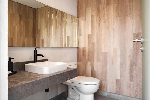 a bathroom with a white toilet and a sink at Casa Cibeles by Lumina in Mexico City