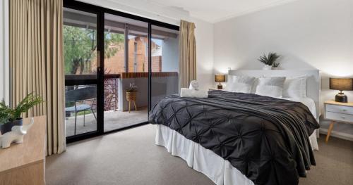a bedroom with a large bed and a balcony at Forest Edge Villa - Family Friendly - Walk To Town in Margaret River Town
