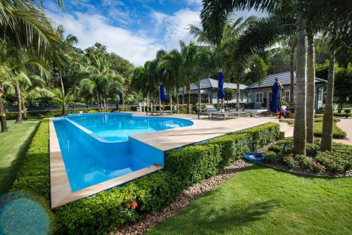 a swimming pool in a yard with palm trees at Grande Sun Seaside Villas Koh Chang in Ban Dan Kao