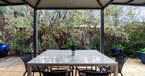 a white table and chairs on a patio with a fence at Forest Edge Villa - Family Friendly - Walk To Town in Margaret River Town