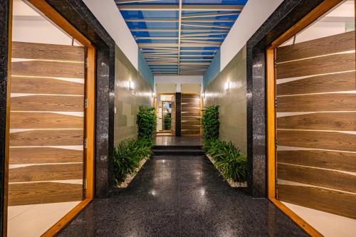 an office corridor with wooden doors and plants at S R Premium Suites in Mysore