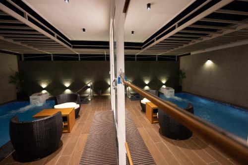 a swimming pool in a hotel with tables and chairs at S R Premium Suites in Mysore