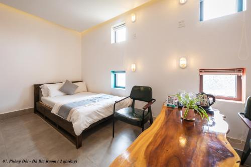 a bedroom with a bed and a desk with a chair at PAMY Homestay Phú Yên in Phu Yen